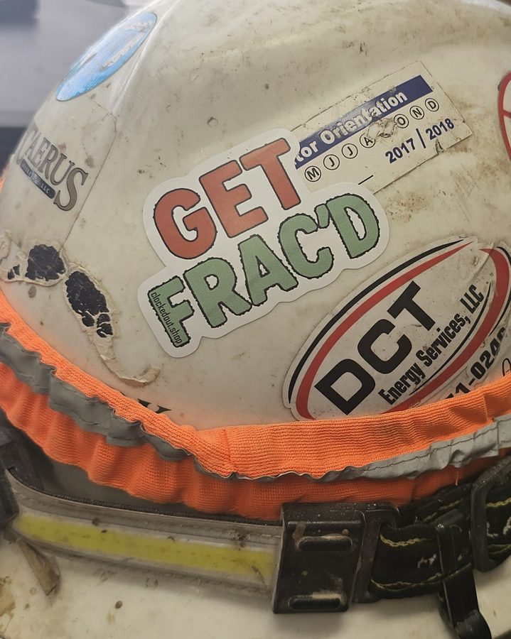 Clocked Out sticker on a worn oilfield hard hat